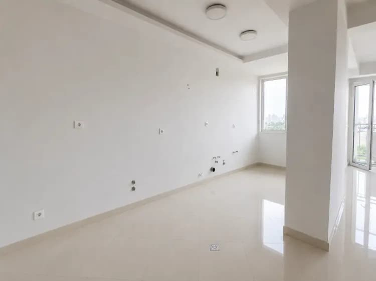 فضای خالی آشپزخانه در پروژه چیتگر پیش از نصب کابینت، با دیوار سفید، کف سرامیکی روشن و محل آمادهشده برای اجرای تأسیسات و کابینت